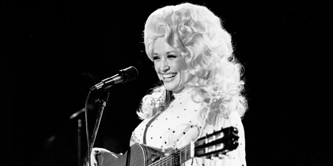 Dolly Parton performing in her signature voluminous blonde wig.
