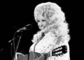 Dolly Parton performing in her signature voluminous blonde wig.