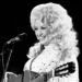 Dolly Parton performing in her signature voluminous blonde wig.